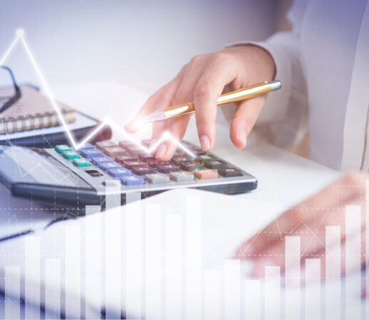 Accountant calculating profit with financial analysis graphs. Notebook, glasses and calculator lying on desk. Accountancy concept. Cropped view.